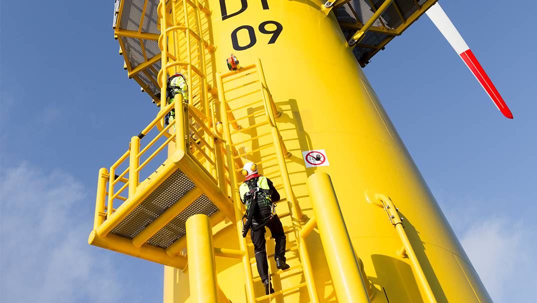 Technician climbing a wind turbine